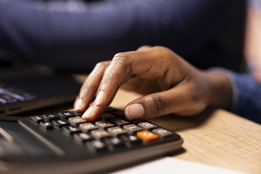 A member working through loan repayment figures on a calculator before borrowing