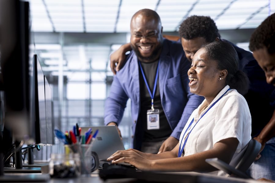 Members gathered around a laptop, offering advice and support to a fellow member launching a business