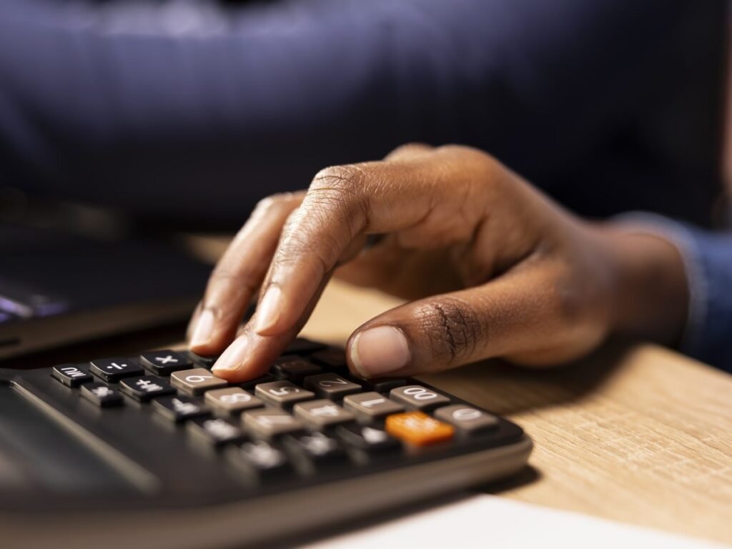 Hands working through loan repayment figures on a calculator